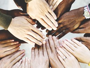 different peoples hands joining together in the centre as part of a team