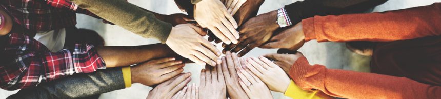 different peoples hands joining together in the centre as part of a team