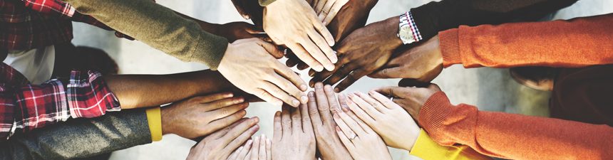 different peoples hands joining together in the centre as part of a team