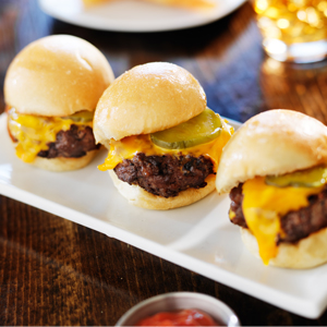 three mini burger sliders on a rectangular plate