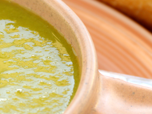 pea soup in a bowl with crusty bread roll